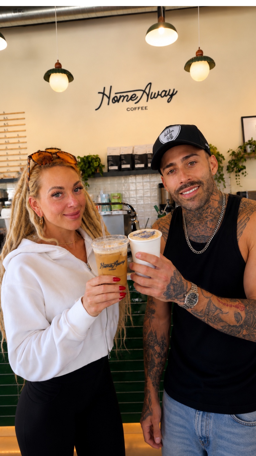 Lana and Kyle holding their seasonal lattes inside Home Away Coffee in Denver