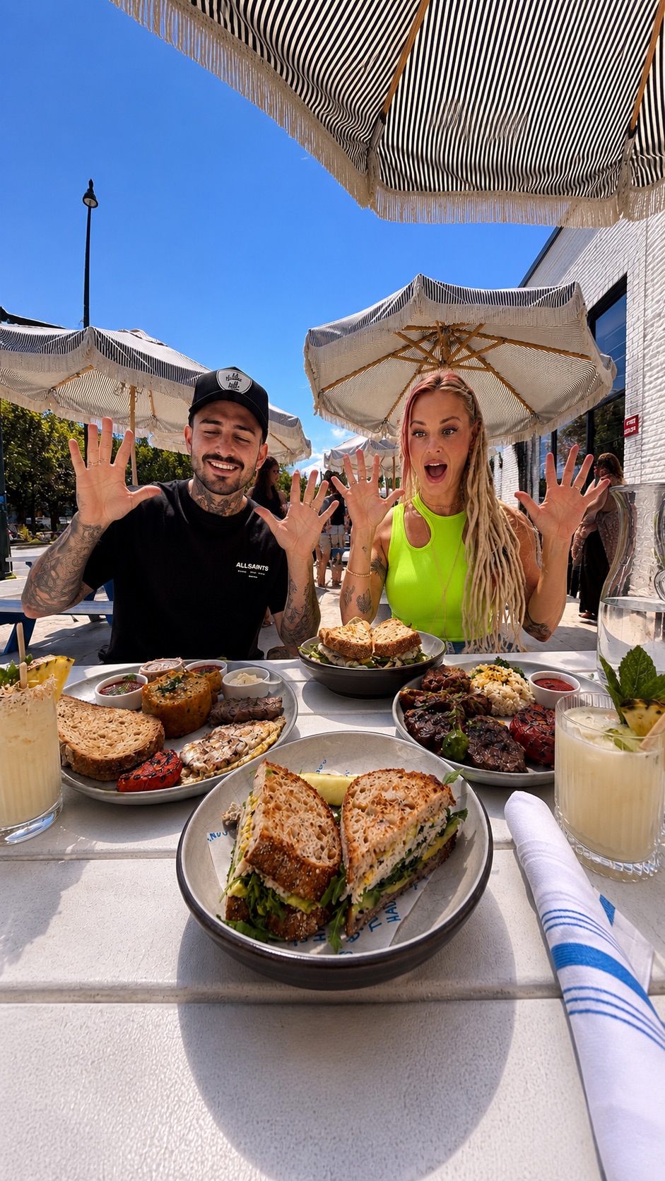 Lana and Kyle with a full brunch table on the patio at Two Hands Denver